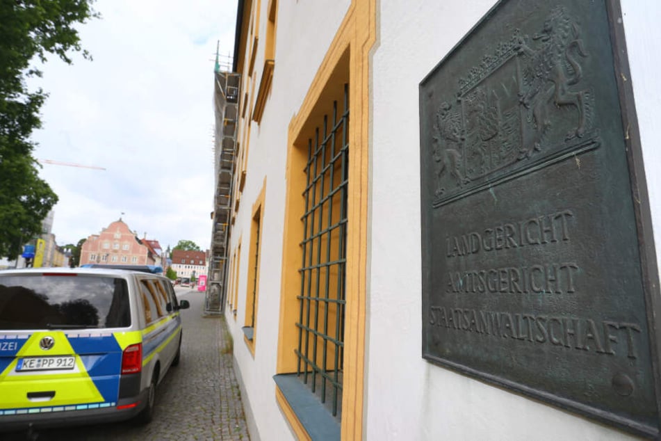 Ein Polizeiauto steht vor dem Land- und Amtsgericht in Kempten. Ab 16.04.2019 muss sich vor dem Landgericht ein 35 Jahre alter Mann wegen Mordes verantworten.