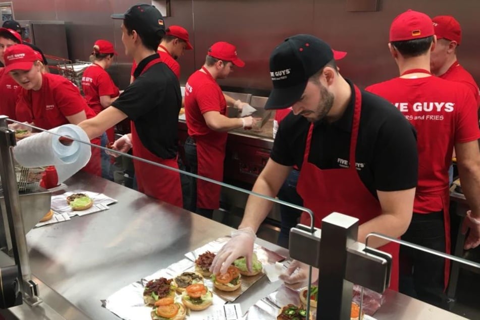 Die ersten Burger werden von den Mitarbeitern zubereitet.