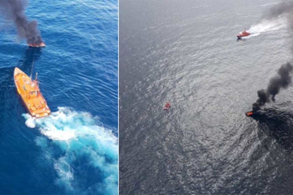 Ein Feuerwehrschiff ist im Einsatz, um das brennende Boot zu löschen.