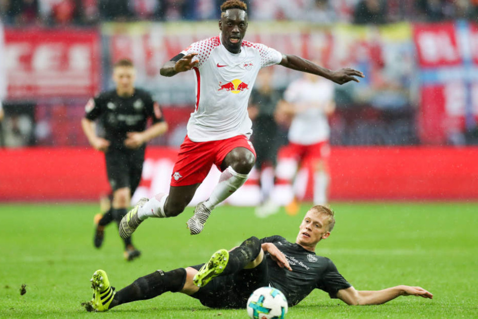 Leipzigs Jean-Kevin Augustin springt über Stuttgarts Timo Baumgartl.