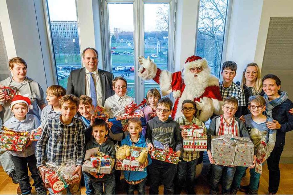 Kein Kind blieb ohne Geschenk - Weihnachtsmann und OB Dirk Hilbert (hinten) hatten alle Hände voll beim Verteilen der Gaben zu tun.