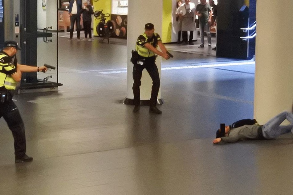 Polizisten richten ihre Waffen auf den verwundeten Täter (19).