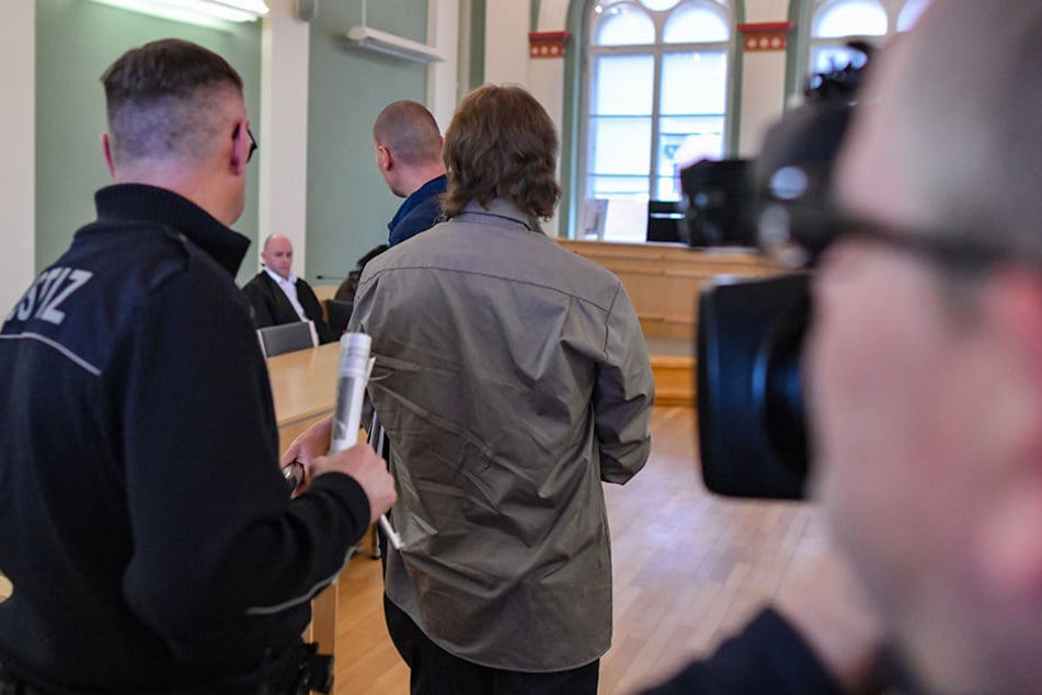 Der Angeklagtewird in einen Verhandlungssaal des Landgerichts Cottbus geführt.