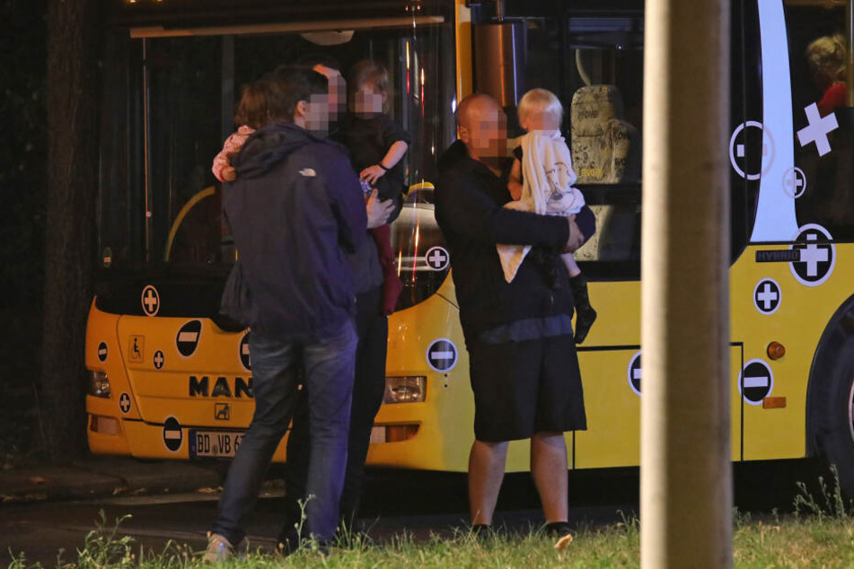Bewohner mit ihren Kindern am Bus der DVB, der bereitgestellt wurde, um die Menschen zu versorgen.