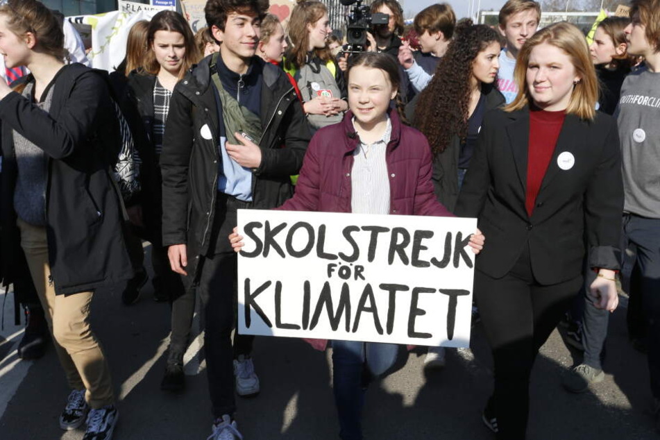 Die Klimaaktivistin Greta Thunberg hält ein Protestschild für Klimaschutz in den Händen.