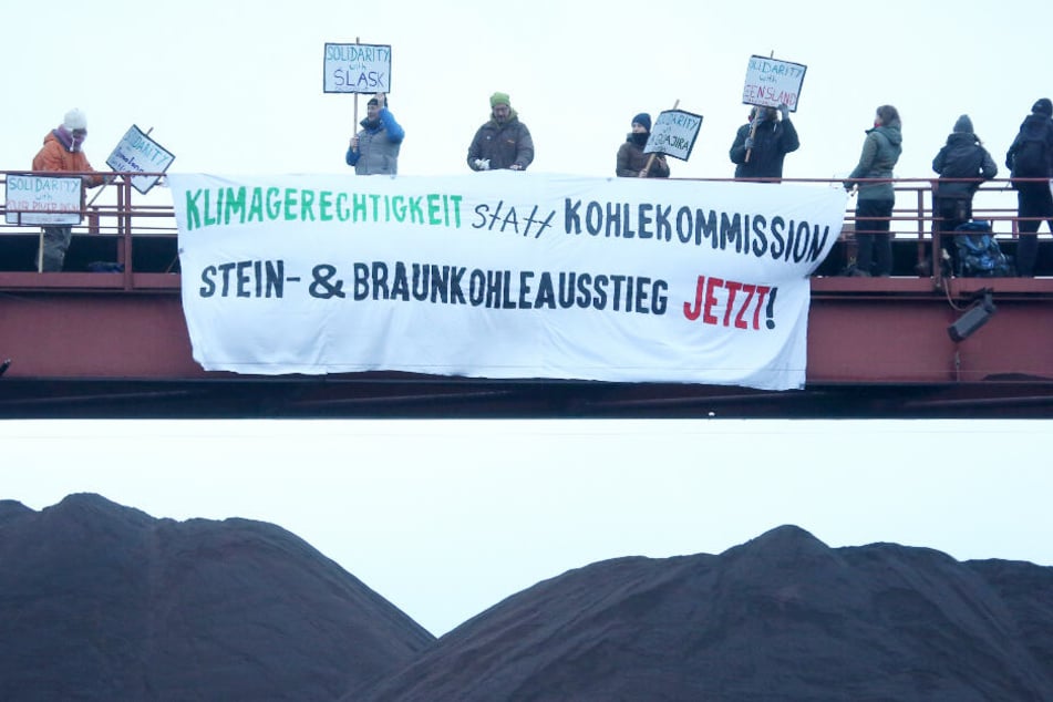 Mit mehreren Plakaten machen die Demonstranten auf sich aufmerksam.