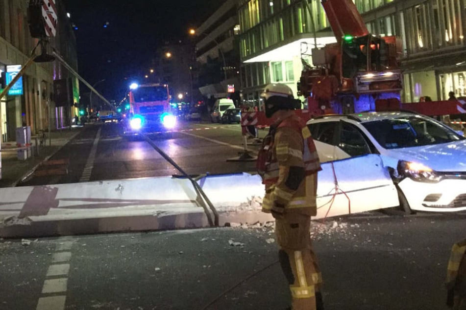 Mit einem Feuerwehrkran transportieren die Rettungskräfte den Pfeiler von der Straße.