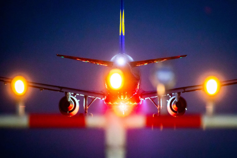 Ein Flieger landet bei Dunkelheit am Frankfurter Flughafen. (Symbolbild)