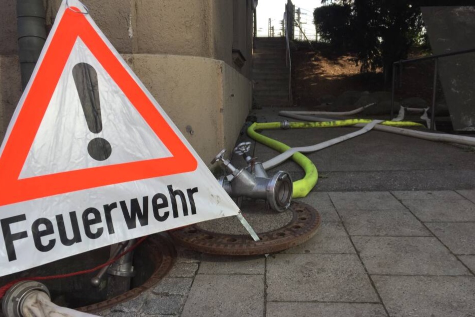 In der Arnulfstraße, wo Feuerwehr und THW den vollgelaufenen S-Bahn-Tunnel auspumpen, steht ein Schild der Feuerwehr neben Schläuchen.