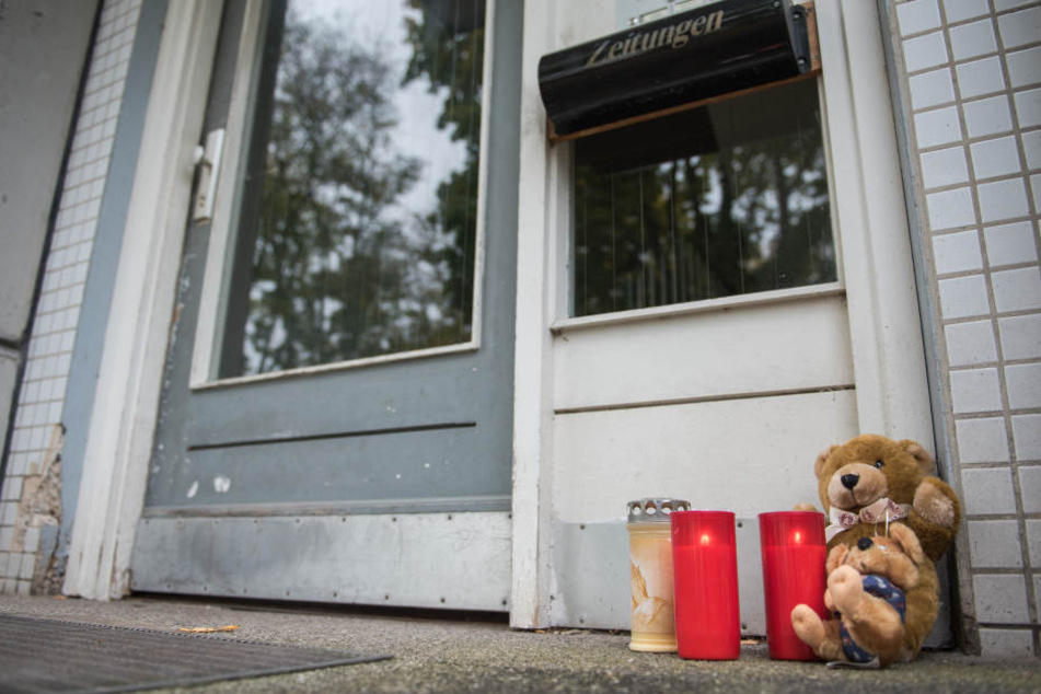 Vor der Wohnung der getöteten Zweijährigen liegen Kerzen und Kuscheltiere.