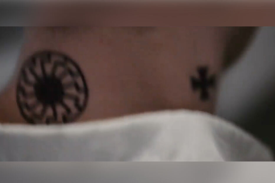 Die "Schwarze Sonne" (links) auf dem Hals einer Filmfigur sorgt für Ärger. (Screenshot)
