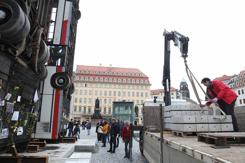 Der Sockel des Bus-Kunstwerks wird mit Beton-Platten beschwert.