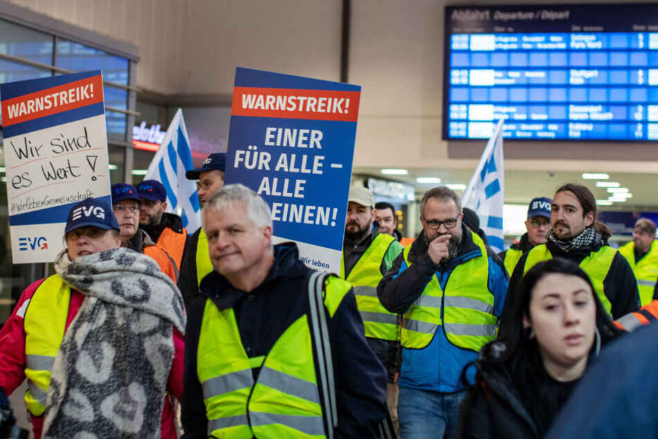 Streikende Mitarbeiter gehen durch den Hauptbahnhof.