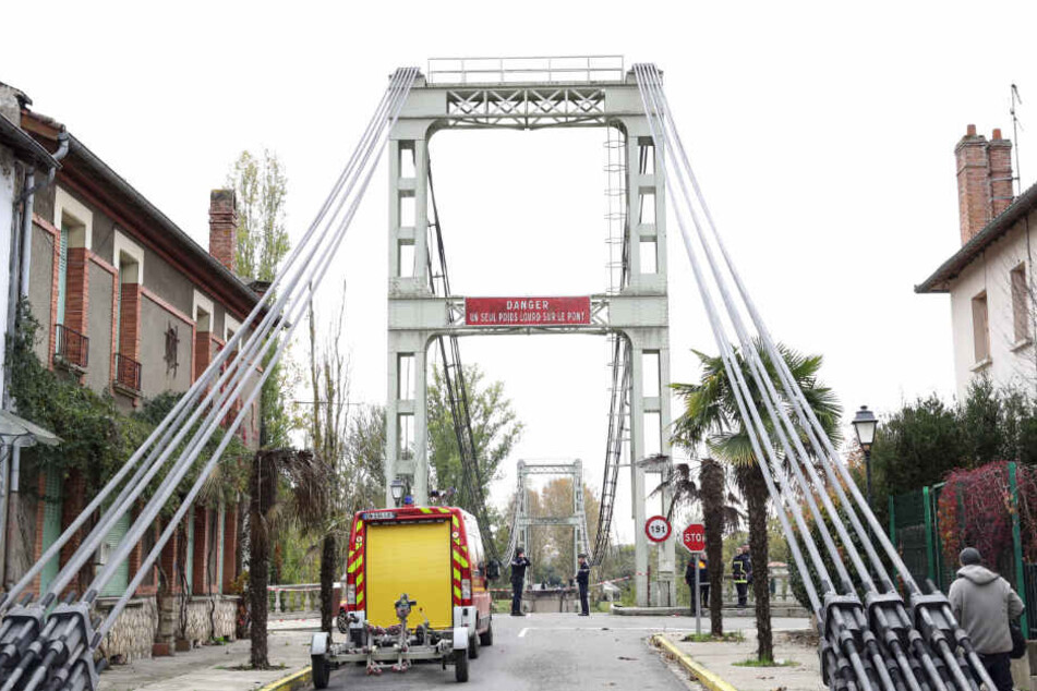 Rettungskräfte stehen vor der abgesperrten Brücke.