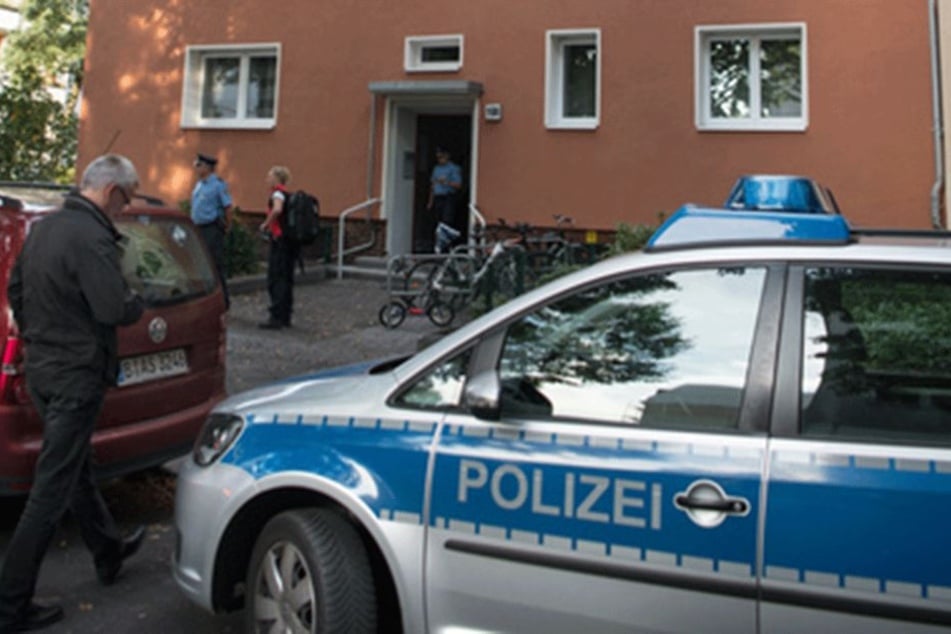 Polizisten stehen vor dem Haus, in dem die zwei Leichen gefunden wurden.