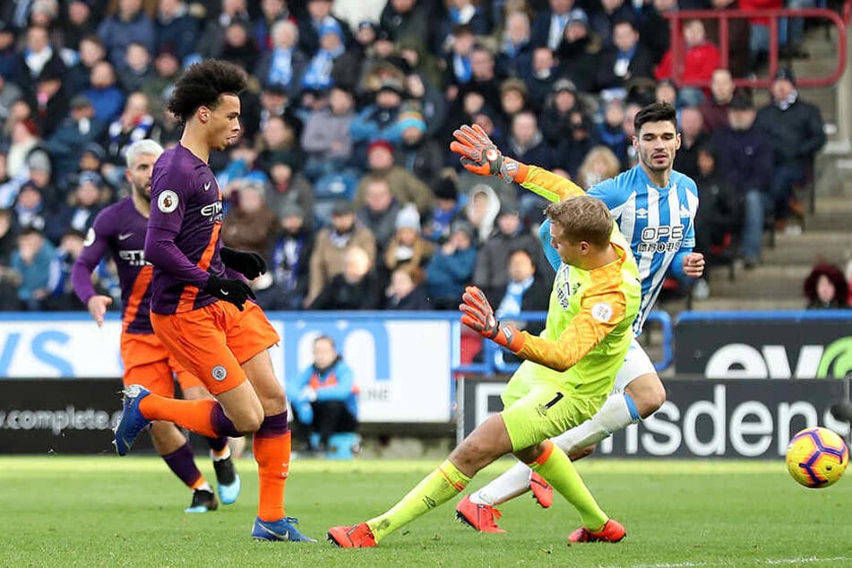 Traf am Sonntag gegen Huddersfield Town zum 3:0-Endstand: Leroy Sané setzt sich hier gegen Torwart Jonas Lössl (M.) und den Deutschen Christopher Schindler (r.) durch.