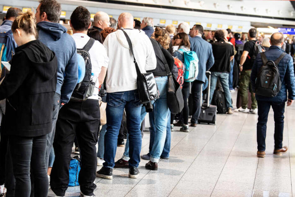 Nach der Annullierung zahlreicher Flüge warten Passagiere im Terminal 1 des Flughafens auf ihre Abfertigung.