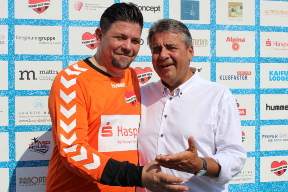 Tim Mälzer und Sigmar Gabriel halten sich nach dem Spiel in den Armen.