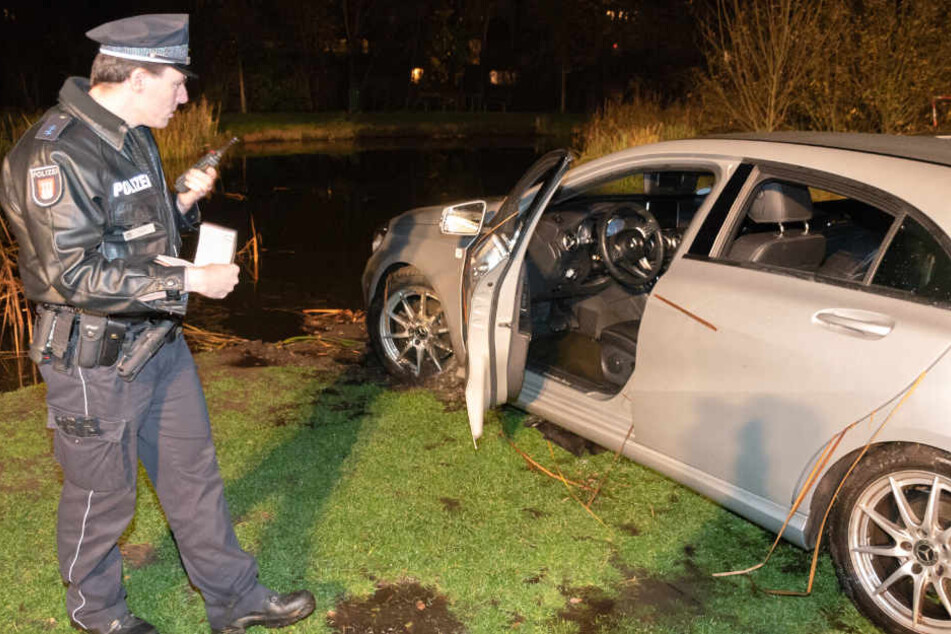 Nachdem der Mietwagen an Land gezogen wurde, nimmt ihn die Polizei genauer unter die Lupe.