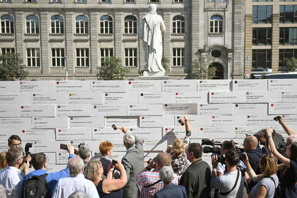 Politiker, Aktivisten und Passanten schlagen auf dem Gendarmenmarkt auf eine Mauer mit Steinen aus Styropor ein.