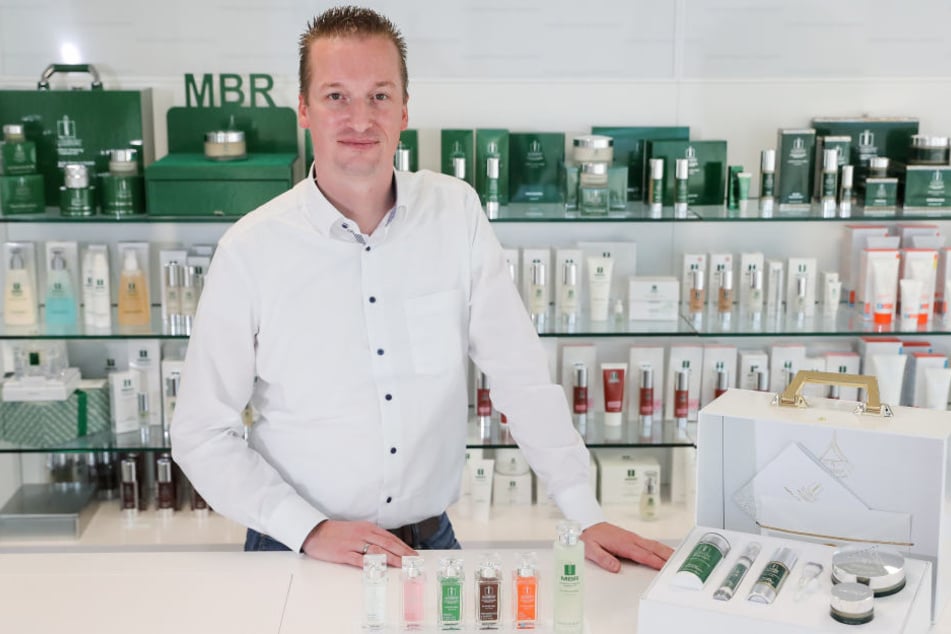 Ronald Behrens, Mitglied der Geschäftsleitung, steht zwischen verschiedenen Pflegeprodukten der Medical Beauty Research GmbH (MBR).