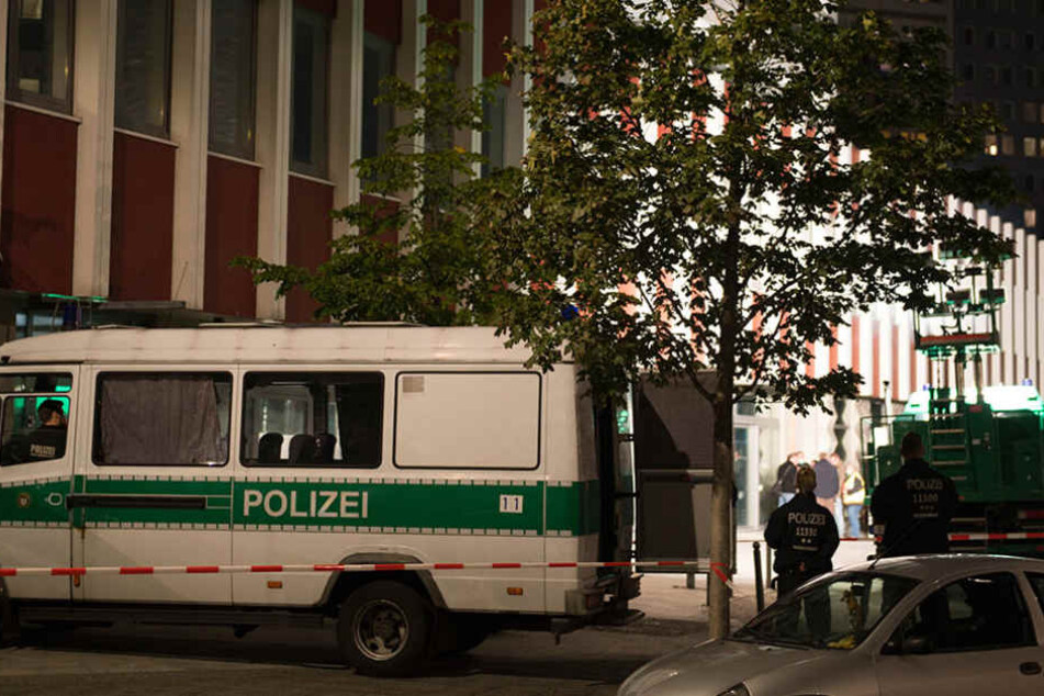 Einsatzfahrzeuge der Polizei stehen in Berlin im Stadtteil Mitte am Abend vor einer Absperrung.