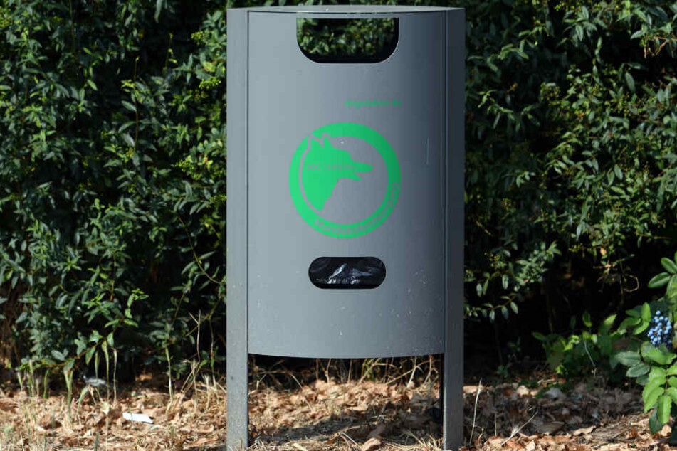 Eine Hundetoilete mit Hundekotbeutelspender steht am Eingang zu einem Park.