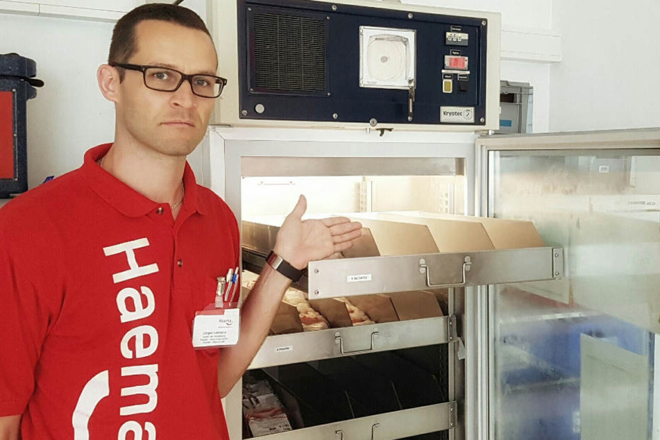 Jürgen Lehmann (36), Leiter der Herstellung, ist besorgt und zeigt auf einen fast leeren Blutdepotlagerschrank.