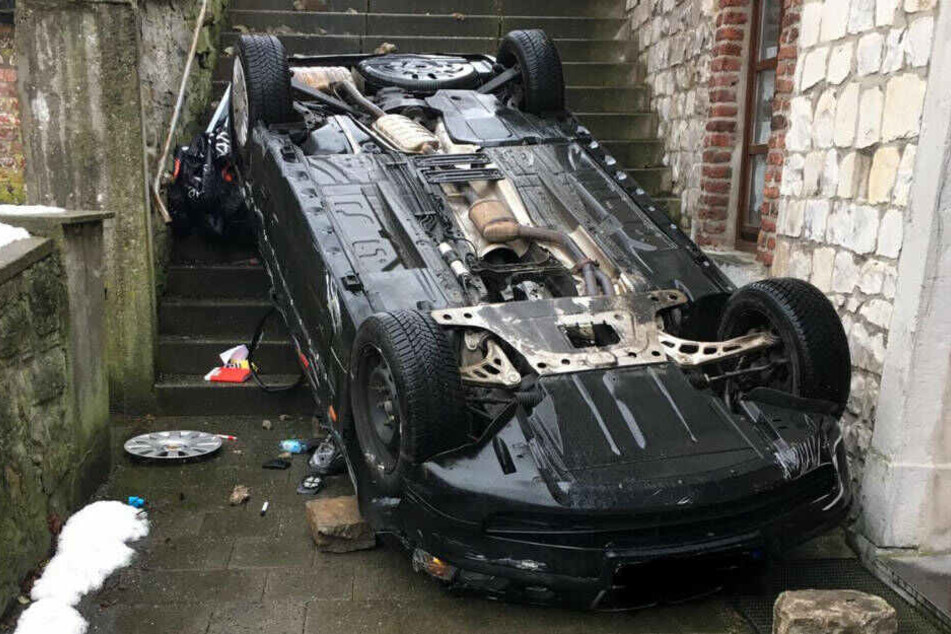 Nachdem es die Treppe herunter gestürzt war, blieb das Auto auf dem Dach liegen.