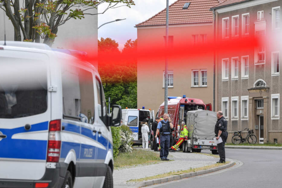Polizeibeamte und Kriminaltechniker stehen in der gesperrten Amtstraße.