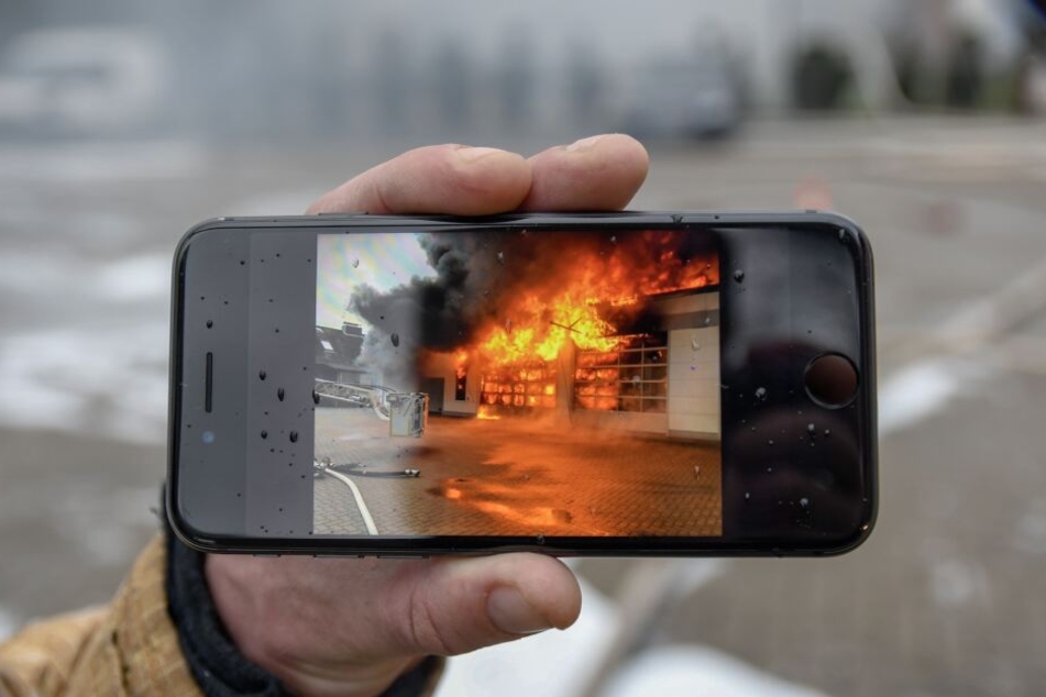 Das Foto auf dem Smartphone eines Feuerwehrmannes zeigt die volle Ausdehnung der Flammen.