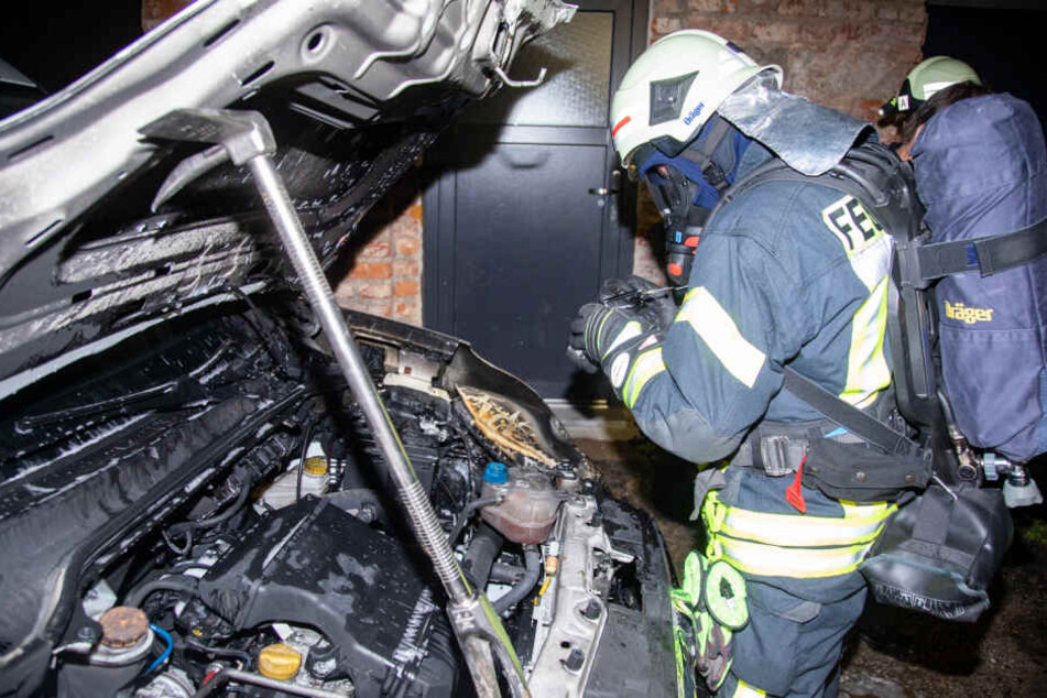 Ein Feuerwehrmann aus Bischofswerda dokumentiert in Schutzkleidung den entstandenen Schaden.