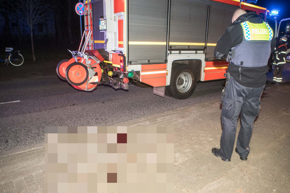 Ein Polizist steht neben einer großen Blutlache auf dem Gehweg.