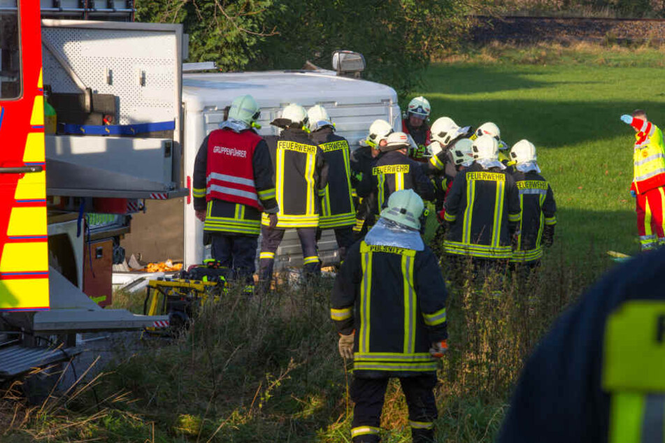 Rettungskräfte versuchen die beiden schwer verletzten Personen aus dem Transporter zu befreien.