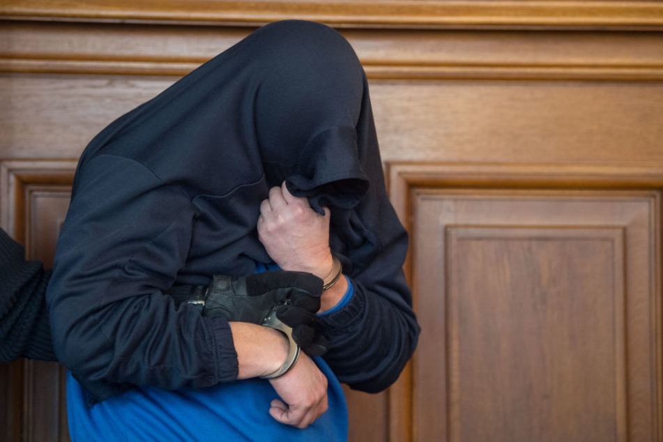Als der Angeklagte den Gerichtssaal betrat, hatte er sein Gesicht mit einem Kleidungsstück verdeckt.