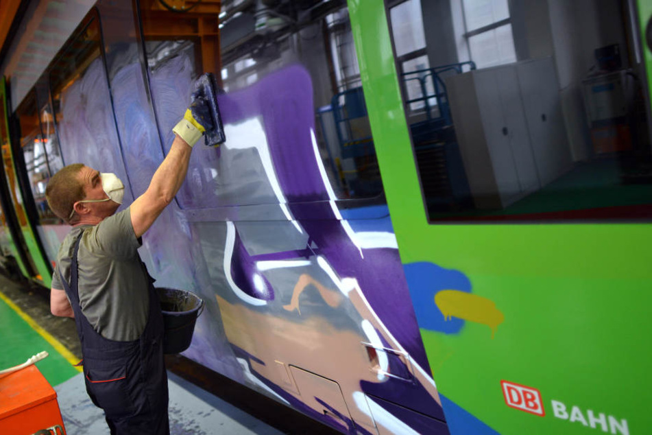 Ein Bahn-Mitarbeiter entfernt Farbe von einer S-Bahn nach einer Sprayer-Attacke. Bei einer weiteren Tat wurden nun in Leipzig sechs Männer festgenommen. (Symbolbild)