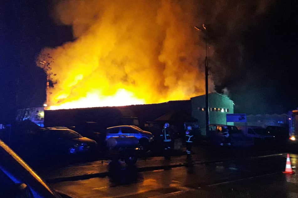 Meterhohe Flammen ragen aus der Lagerhalle.