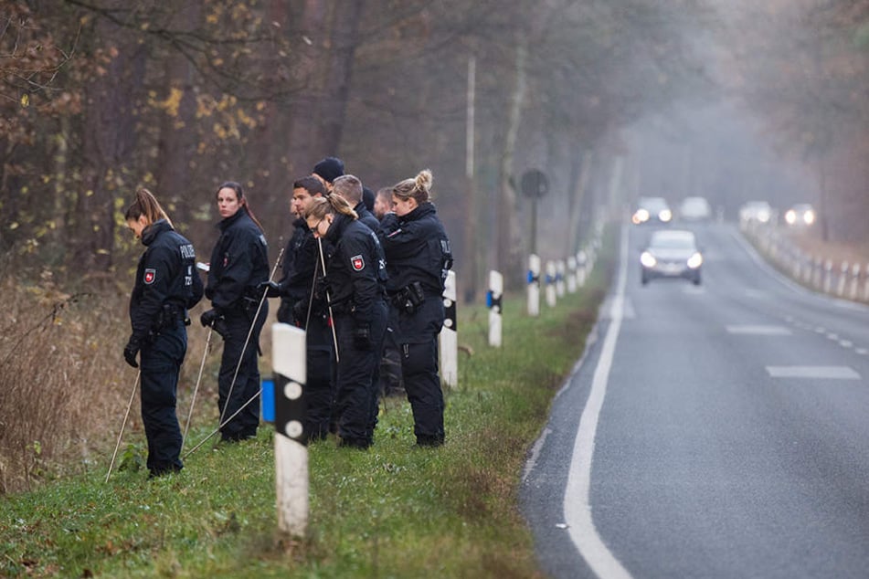 Polizisten suchten in einem Wald an einer Landstraße nach Spuren.