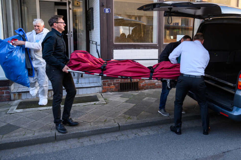 Bestatter schieben einen Leichensack in einen Leichenwagen. Im Zusammenhang mit dem Passauer Armbrust-Fall haben Ermittler zwei Leichen in Niedersachsen gefunden.