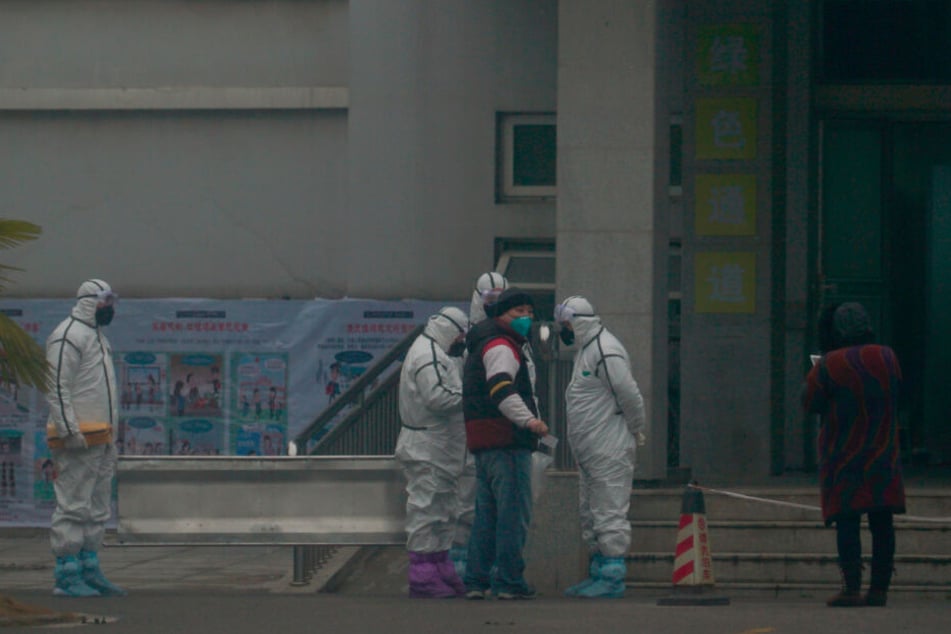 Mitarbeiter in Schutzanzügen stehen vor dem Wuhan Medical Treatment Center, in dem ein Patient mit Verdacht auf den neuartigen Corona-Virus behandelt wurde.