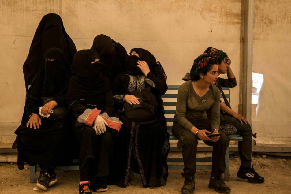 Frauen, die mit IS-Kämpfern verwandt sind, sitzen im Flüchtlingslager Al-Hol in Syrien.
