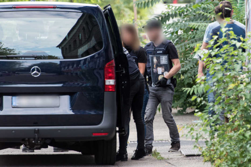 Polizisten tragen vor dem autonomen Zentrum "KTS" in Freiburg bei einer Durchsuchung Beweismaterial zu einem Polizeifahrzeug.