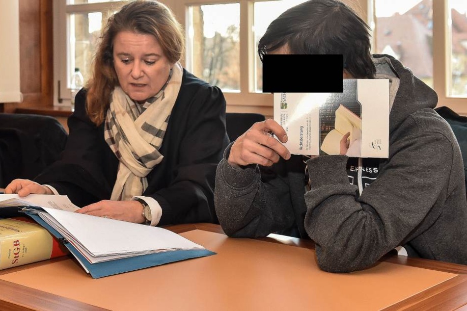 Philipp G. versteckt sein Gesicht hinter eine Justiz-Broschüre.