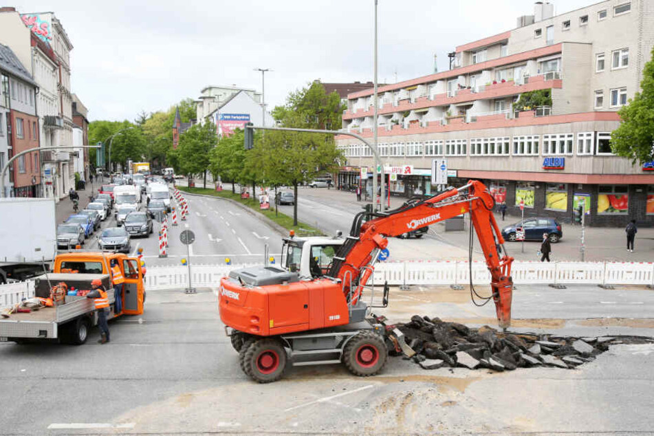 Ein Bagger reißt die Max-Brauer-Allee auf. Was hier nach einem Rohrbruch geschah, soll im Jahr 2021 auf der ganzen Straße passieren.