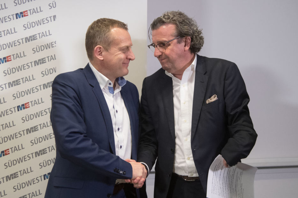 Stefan Wolf (r.), der Vorsitzende der Arbeitgebervereinigung Südwestmetall und Roman Zitzelsberger, der Bezirksleiter der IG Metall Baden-Württemberg, geben sich in der Liederhalle nach einer Pressekonferenz zum Abschluss der Tarifverhandlungen die Hand.