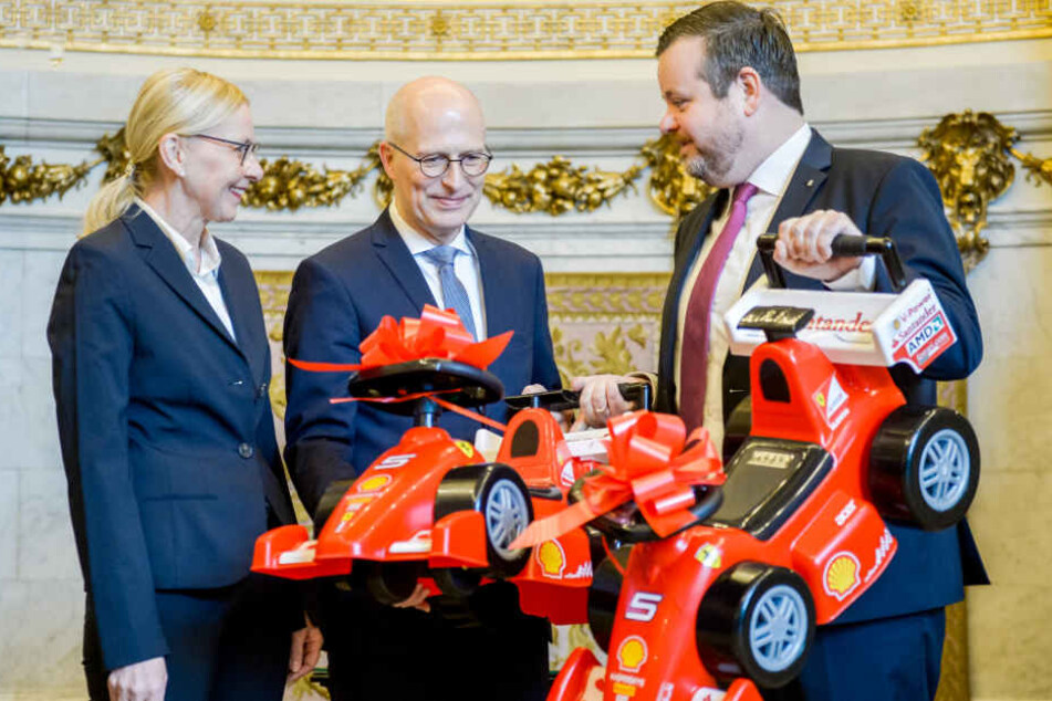 CDU-Fraktionschef André Trepoll (rechts) überreichte Bürgermeister Peter Tschentscher zwei ferrarirote Bobby-Cars für Hamburgs Zweite Bürgermeisterin, Katharina Fegebank.