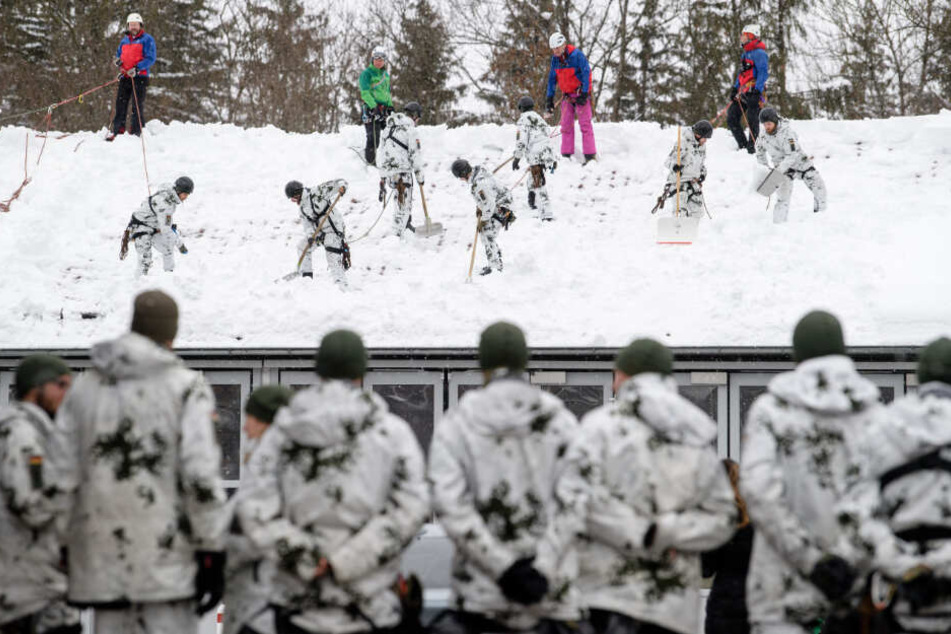 Helfer befreien das Dach der Straßenmeisterei von den Schneemassen.