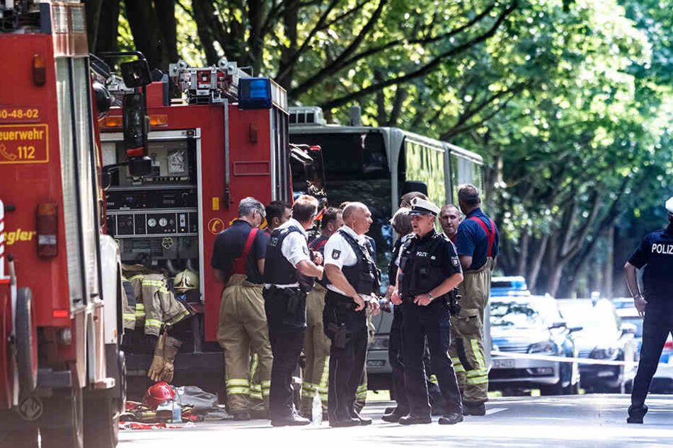 Einsatzkräfte stehen vor dem Bus im Lübecker Stadtteil Kücknitz, in dem am Nachmittag ein Fahrgast Mitreisende mit einem Messer attackiert hatte.