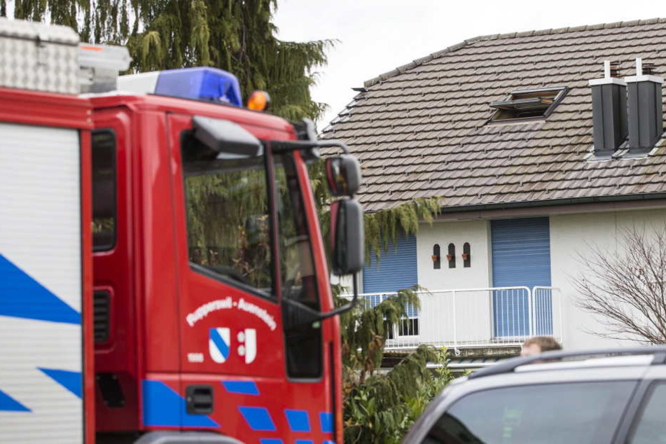 Ein Feuerwehrauto steht vor dem Haus, in dem vier Leichen mit durchgeschnittener Kehle gefunden wurden.
