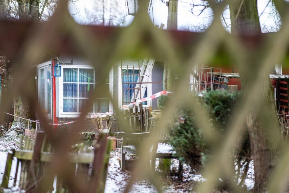 Blick durch einen Zaun auf ein Gebäude auf dem Campingplatz Eichwald, das mit einem Polizeiabsperrband versehen ist.